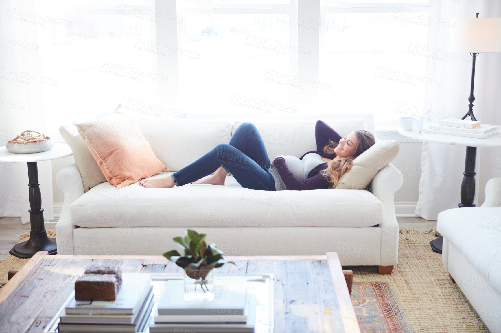 Buy stock photo Full length shot of an attractive young pregnant woman taking a nap on the sofa at home