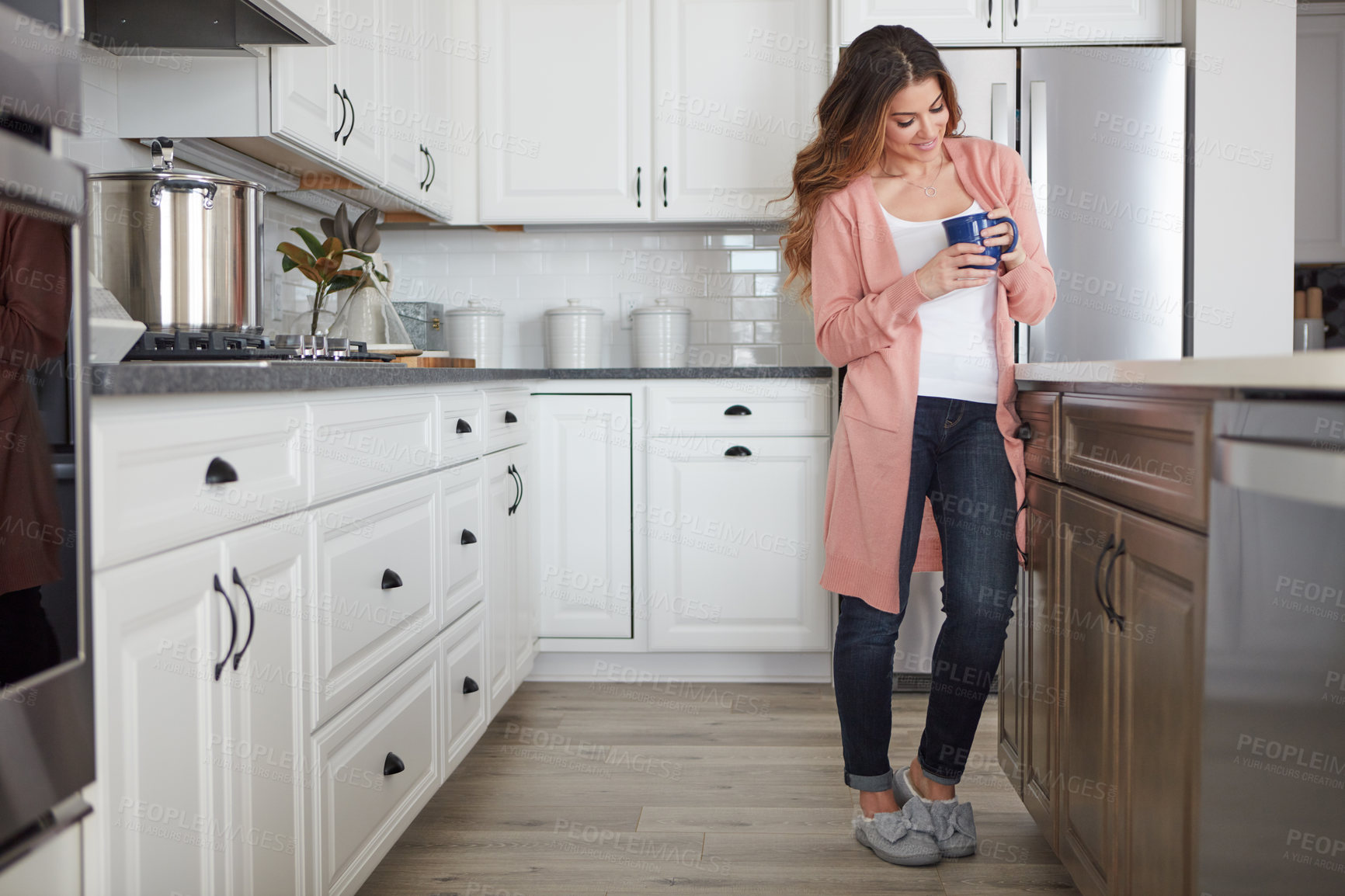 Buy stock photo Shot of a beautiful young woman having coffee in the kitchen at home