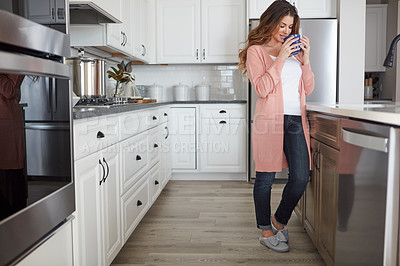 Buy stock photo Shot of a beautiful young woman having coffee in the kitchen at home