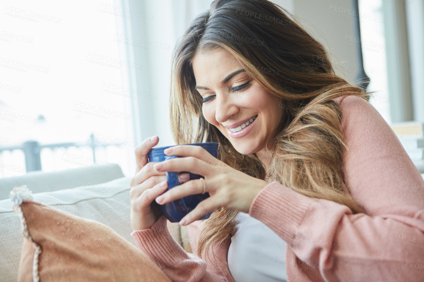 Buy stock photo Shot of a beautiful young woman having coffee while relaxing at home