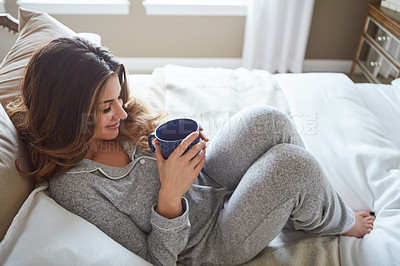 Buy stock photo Shot of a beautiful young woman having coffee during a relaxing morning at home