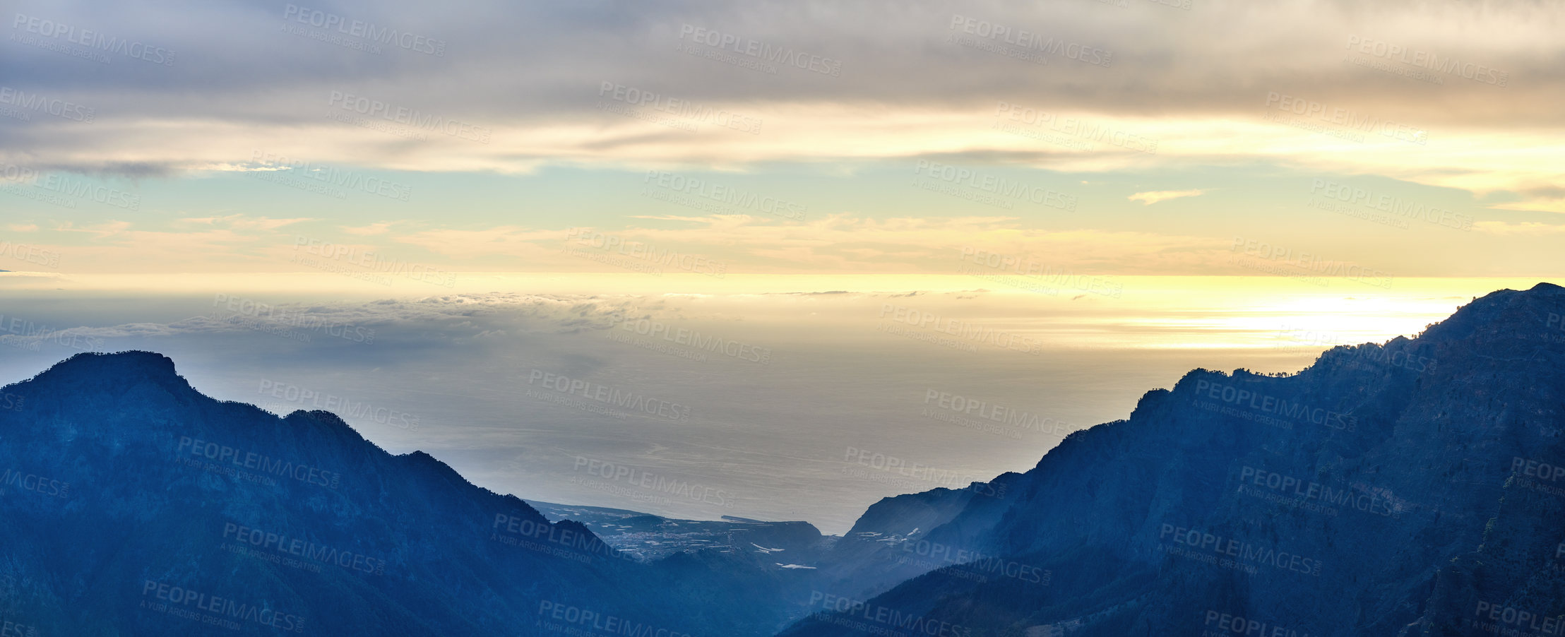 Buy stock photo Beautiful landscape of a mountain during sunset with a cloudy sky on a summer day. Peaceful and scenic view of peaks during a golden sunrise with copy space. Aerial view of uncultivated nature