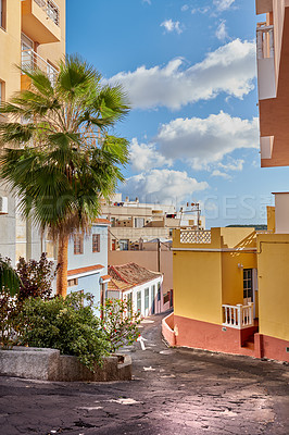 Buy stock photo A vintage city with residential buildings built with historic architecture with a cloudy blue sky. An alley in an old small town with colorful houses and homes. The exterior of an urban village