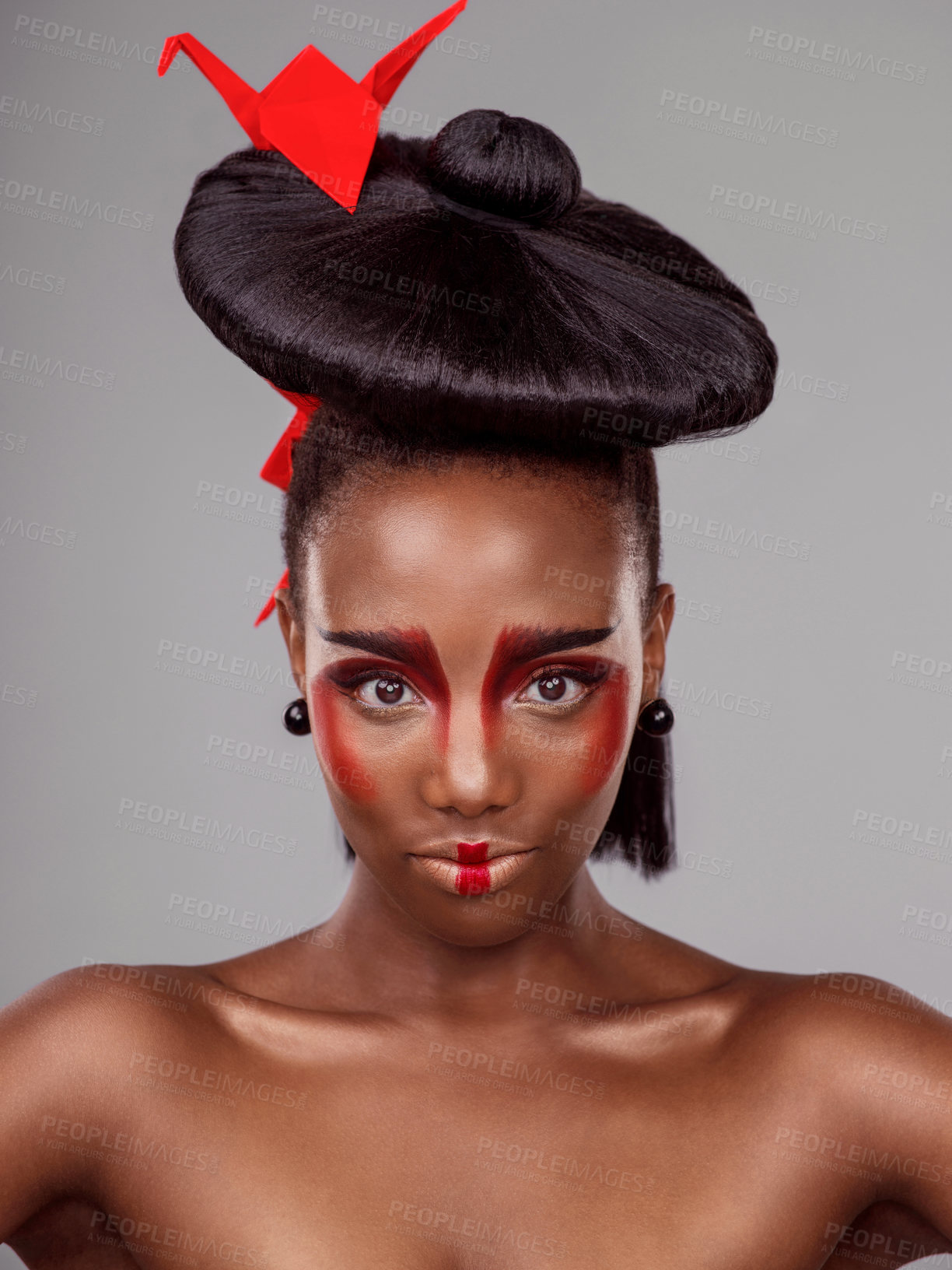 Buy stock photo Portrait, makeup and black woman with origami for beauty in studio isolated on gray background. Face, creative cosmetics and confident model with red paper bird in hair, skincare and Japanese art