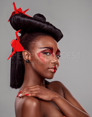 Buy stock photo Portrait, makeup and beauty of black woman with origami in studio isolated on gray background or backdrop. Face, creative cosmetics and confident model with red paper crane in hair, skincare and art