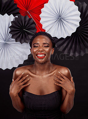 Buy stock photo Beauty, calm and black woman with origami fans in studio, smile and dark background. Face, makeup and cosmetics of female model with pride, traditional Japanese and paper art for culture hat