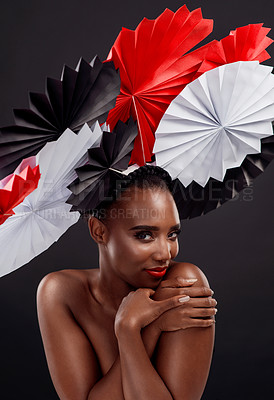 Buy stock photo Black woman, portrait and smile with origami fans in studio isolated on a dark background. Face, makeup cosmetics and skincare of female model with beauty and traditional paper art for geisha hat