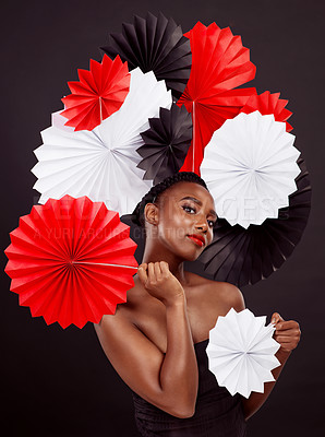Buy stock photo Black woman, origami fans and portrait in studio for beauty with makeup isolated on dark background. Cosmetics, pride and paper art for culture with tradition, skincare and confidence with elegance