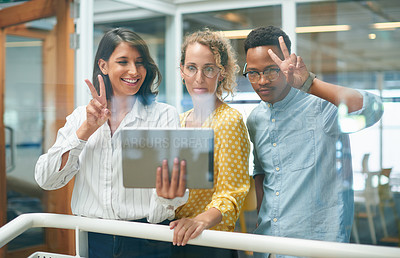 Buy stock photo Shot of a group of young businesspeople taking a selfie together in a modern office