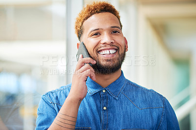 Buy stock photo Shot of a young businessman using a smartphone in a modern office