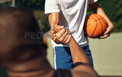 Buy stock photo Closeup shot of two sporty young men shaking hands on a basketball court