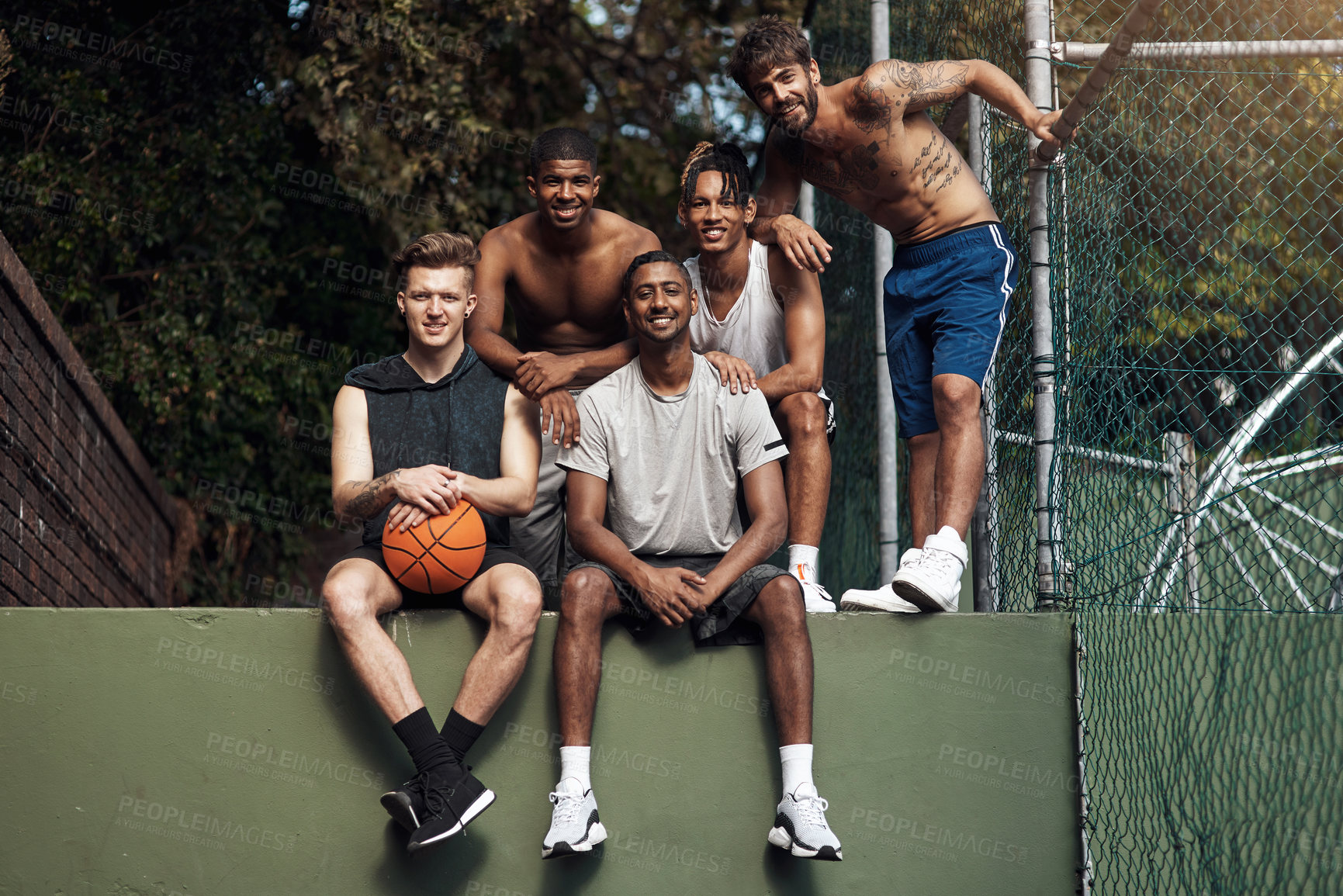 Buy stock photo Portrait of a group of sporty young men hanging out on a basketball court