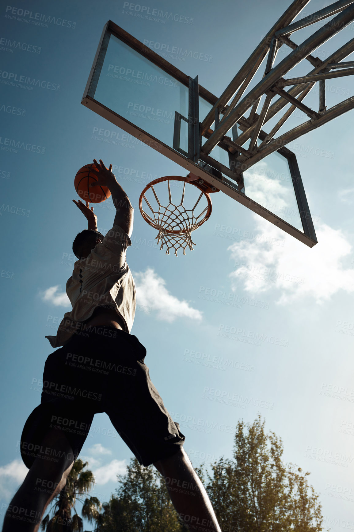 Buy stock photo Shot of a sporty young man playing basketball on a sports court
