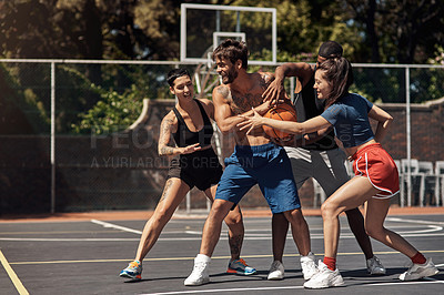 Buy stock photo Shot of a group of sporty young people playing basketball on a sports court