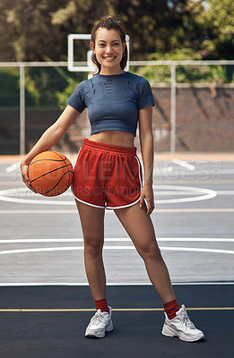 Buy stock photo Portrait of a sporty young woman holding a basketball on a sports court