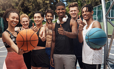 Buy stock photo Portrait of a group of sporty young people showing thumbs up while standing together on a sports court