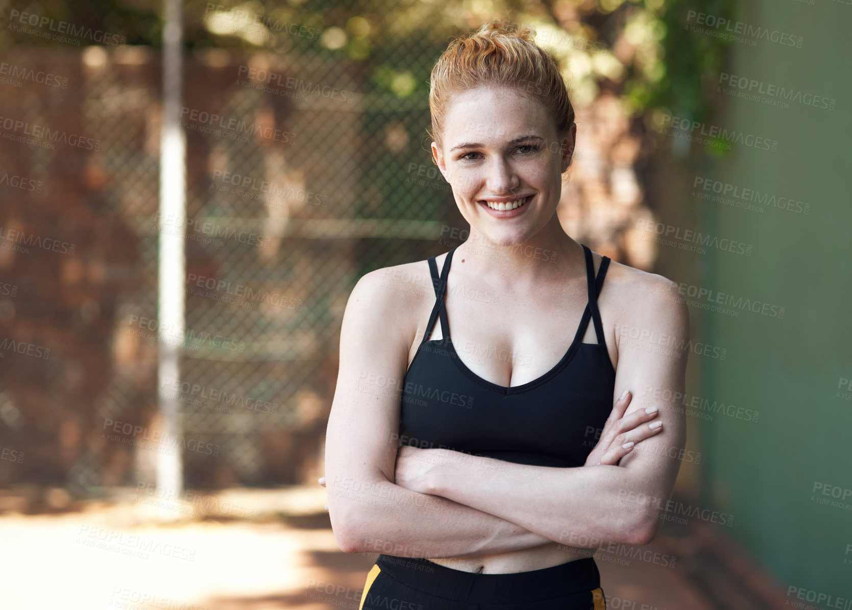 Buy stock photo Cropped portrait of an attractive young female athlete standing with her arms folded on the basketball court