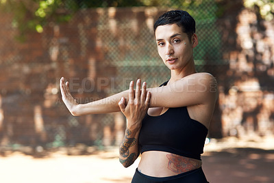 Buy stock photo Cropped portrait of an attractive young female athlete stretching while standing on the basketball court