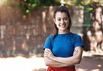 Buy stock photo Cropped portrait of an attractive young female athlete standing with her arms folded on the basketball court