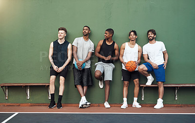 Buy stock photo Shot of a group of sporty young men hanging out on a basketball court