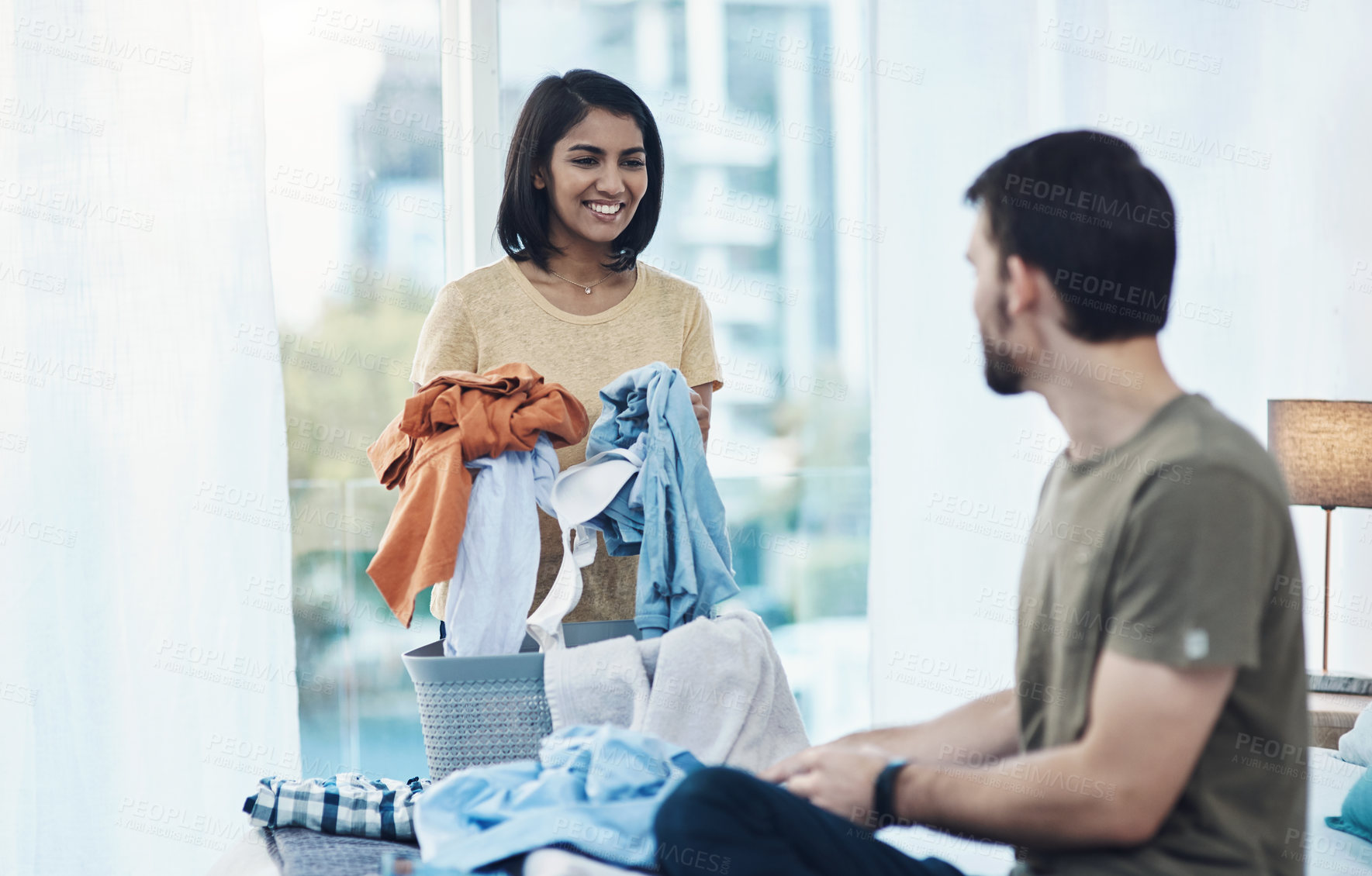 Buy stock photo Shot of a young couple doing laundry together at home