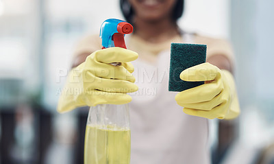 Buy stock photo Shot of an unrecognisable woman using rubber gloves and disinfectant to clean her home