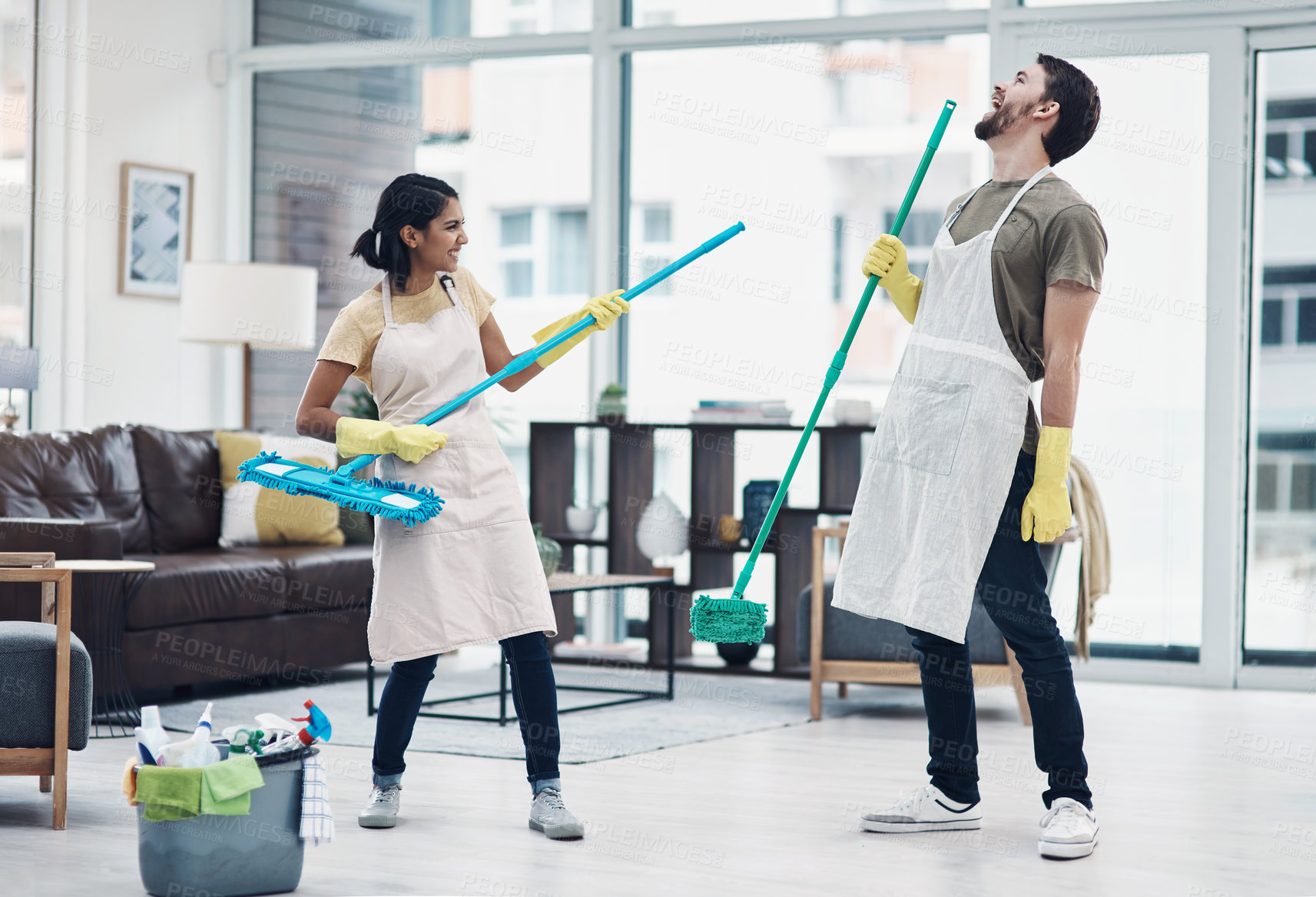 Buy stock photo Shot of a happy young couple having fun while mopping the floor at home