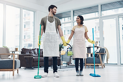 Buy stock photo Shot of a happy young couple mopping the floor together at home