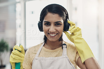 Buy stock photo Shot of a young woman listening to music while cleaning her home