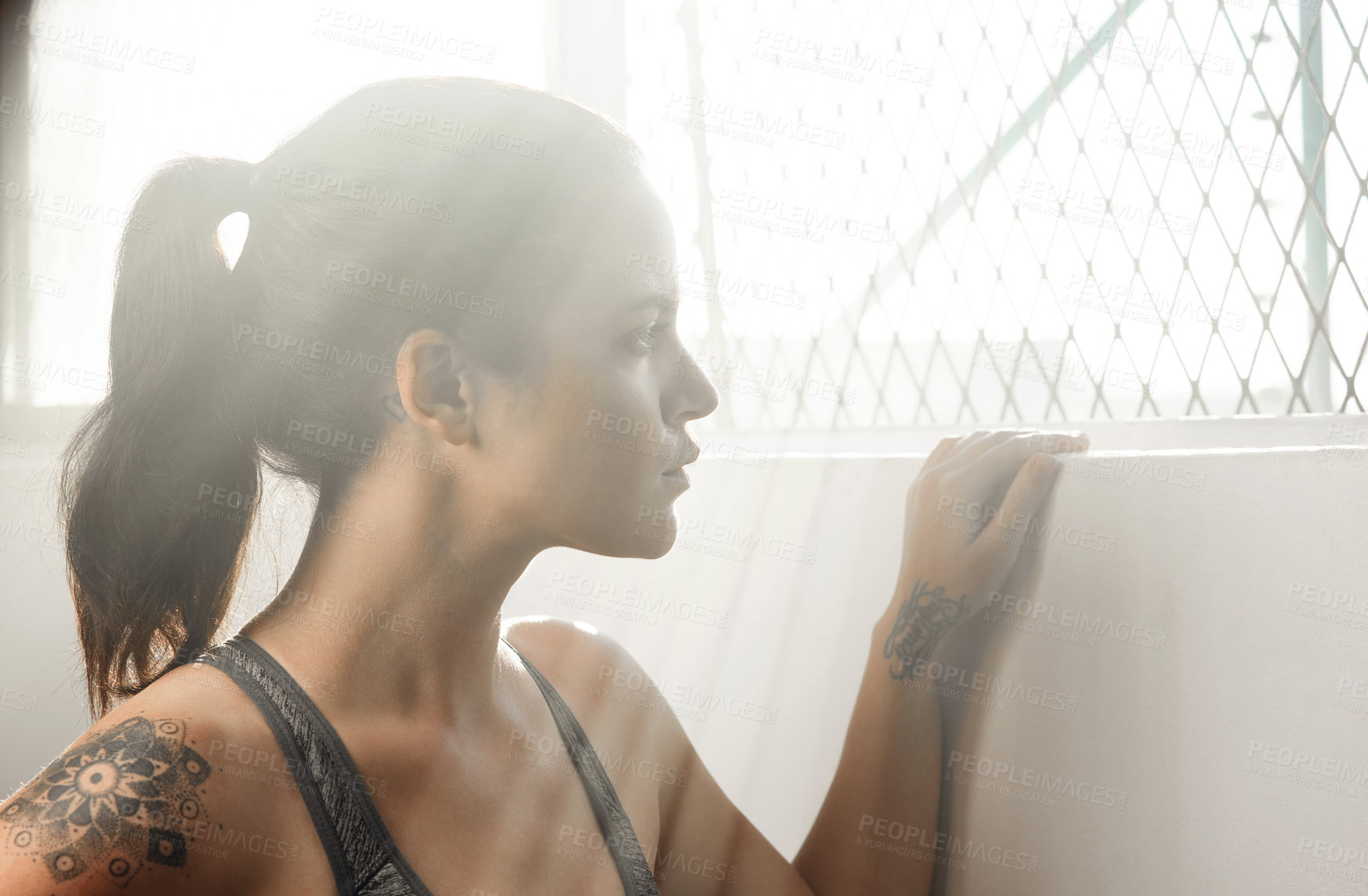 Buy stock photo Cropped shot of a young female athlete looking thoughtful at the gym
