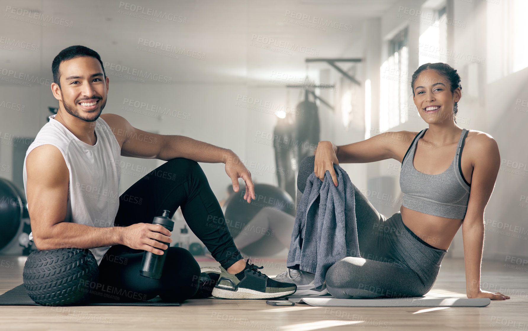 Buy stock photo Shot of two young athletes sitting together at the gym