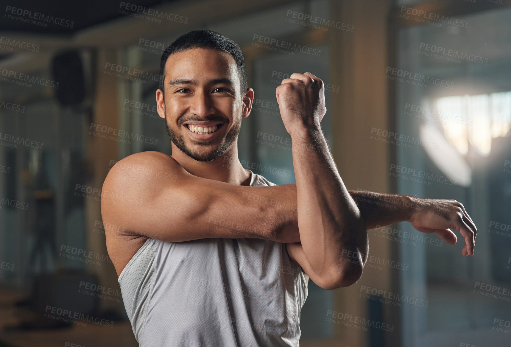 Buy stock photo Cropped portrait of a handsome young male athlete going through his warmup routine in the gym