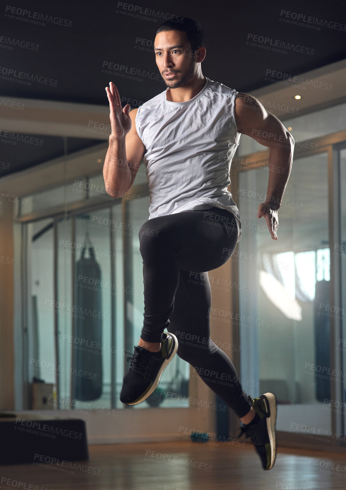 Buy stock photo Full length shot of a handsome young male athlete jumping during his workout in the gym