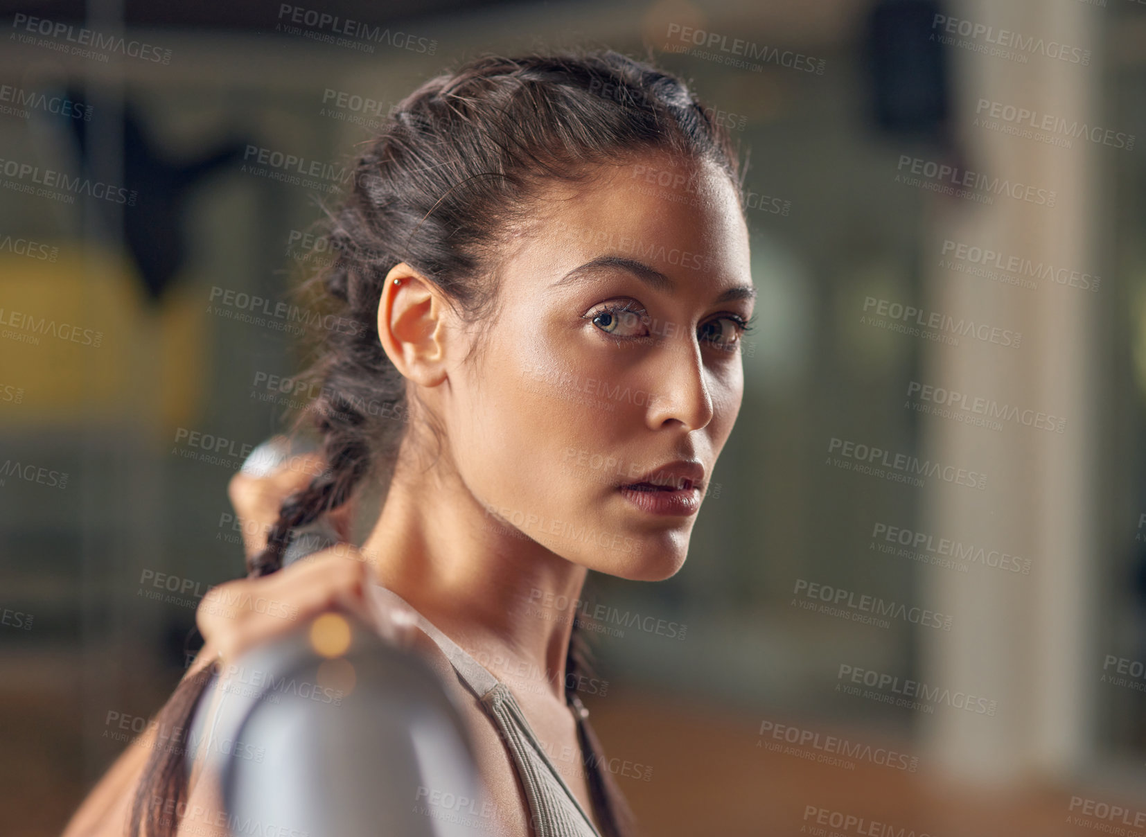 Buy stock photo Cropped portrait of an attractive young female athlete working out with weights in the gym