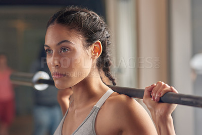 Buy stock photo Cropped portrait of an attractive young female athlete working out with weights in the gym