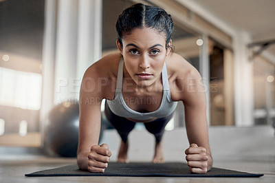 Buy stock photo Full length portrait of an attractive young female athlete planking in the gym