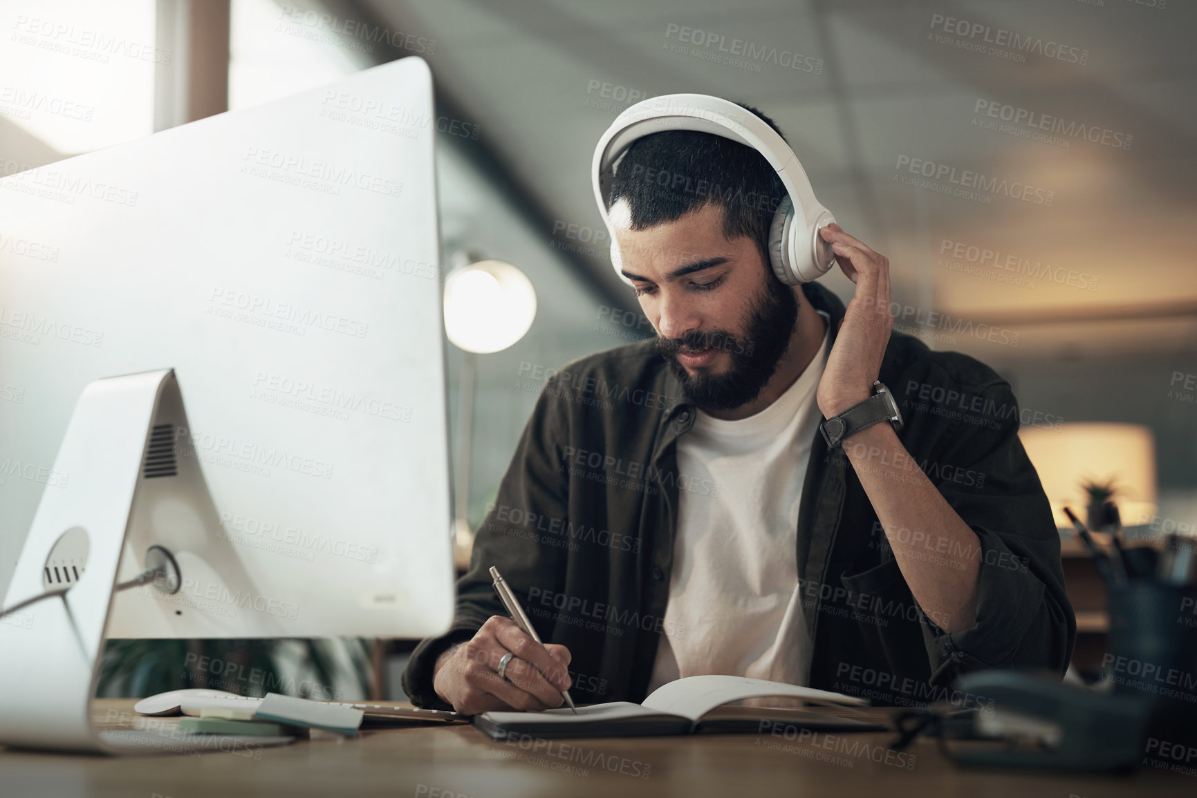 Buy stock photo Creative, man and writing with notebook, night and video editor with ideas and headphones for project. Content creation, deadline and person with tech, post production and design process with music