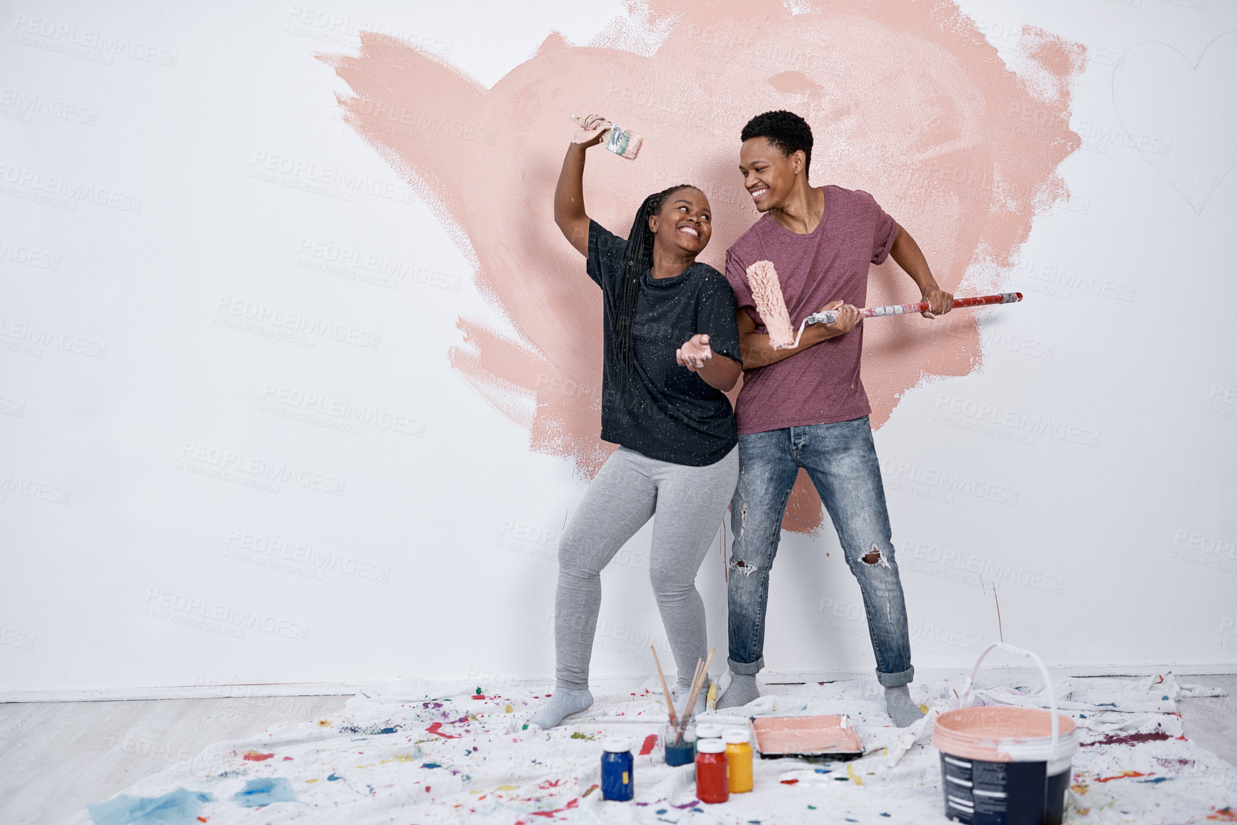 Buy stock photo Black couple, painting fun and wall in home with renovation, love and bonding with art. Paint brush, joy and happy people at property with smile for diy and creative project with care and support