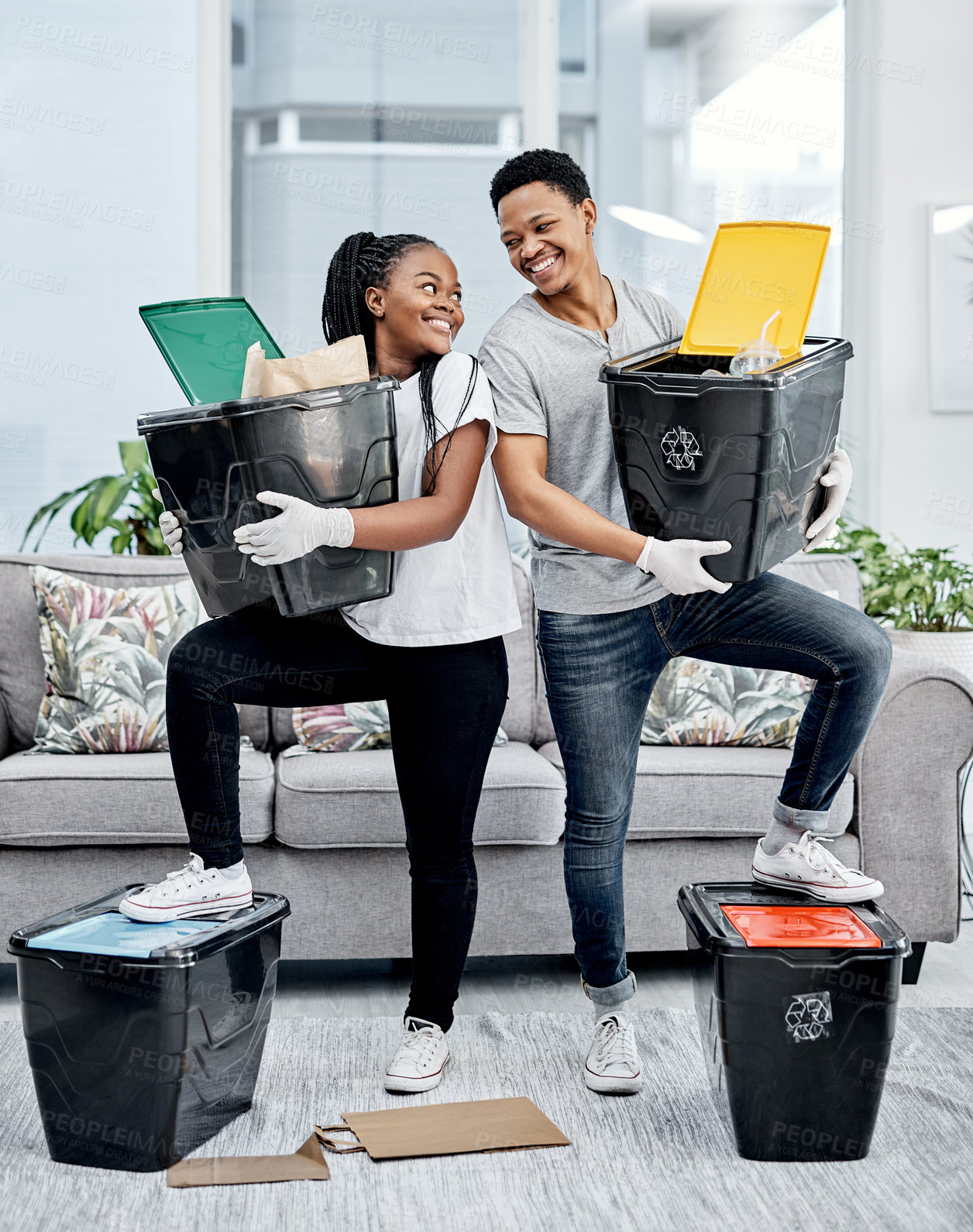 Buy stock photo Shot of a young couple recycling their trash at home