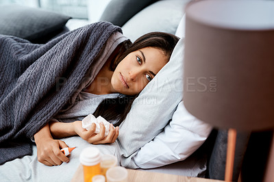 Buy stock photo Shot of a young woman recovering from an illness in bed at home