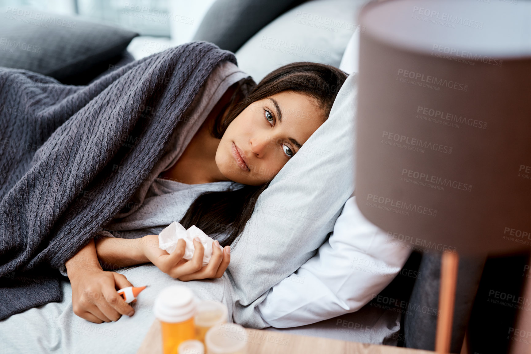 Buy stock photo Shot of a young woman recovering from an illness in bed at home