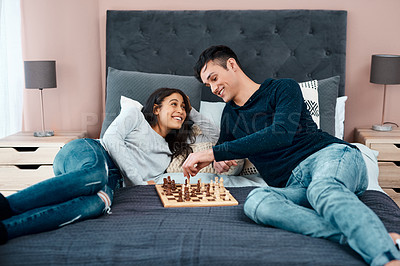 Buy stock photo Shot of a young couple playing a game of chess at home