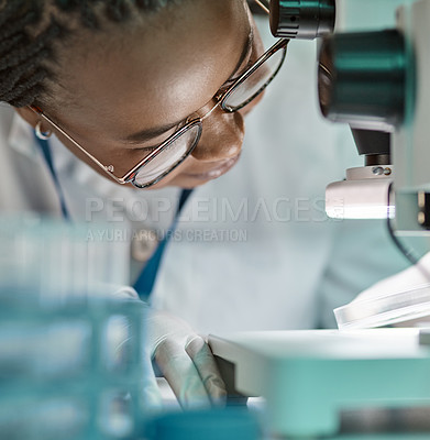 Buy stock photo Shot of a young scientist using a microscope in a lab