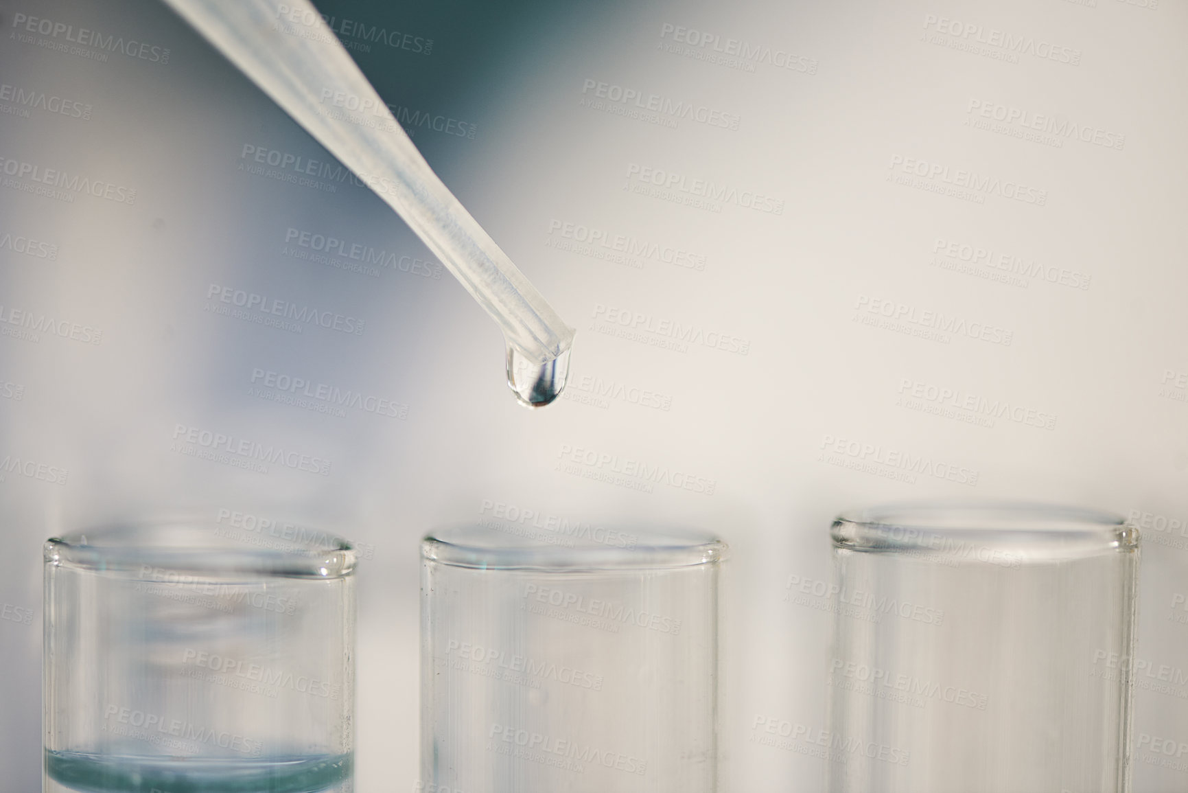 Buy stock photo Closeup shot of liquid from a dropper falling into test tubes in a lab