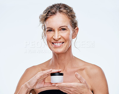 Buy stock photo Shot of a mature woman holding up a beauty product against a while background