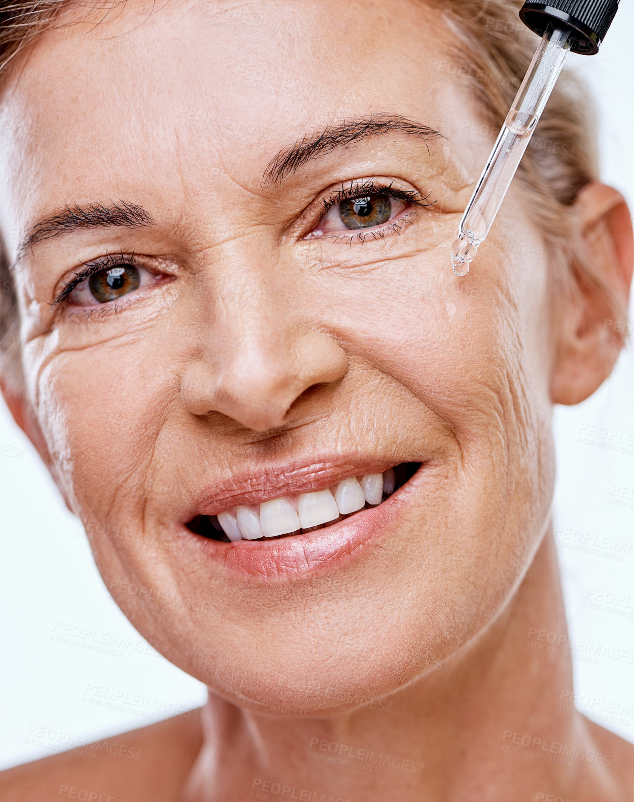 Buy stock photo Shot of a mature woman posing with a serum dropper against her face