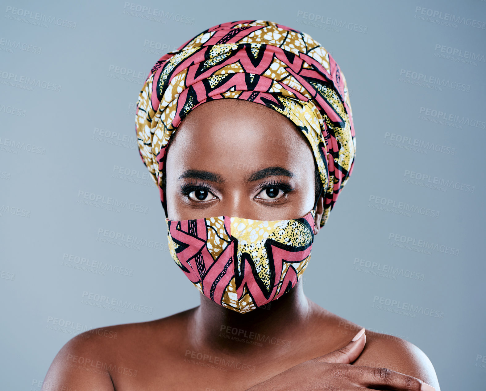 Buy stock photo Studio portrait of a beautiful young woman wearing a mask against a grey background