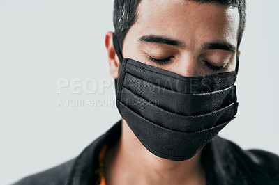 Buy stock photo Studio shot of a masked young man posing against a grey background