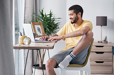 Buy stock photo Shot of a young man using a laptop while working from home