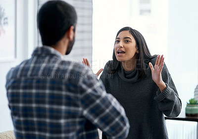 Buy stock photo Shot of a young couple having an argument at home